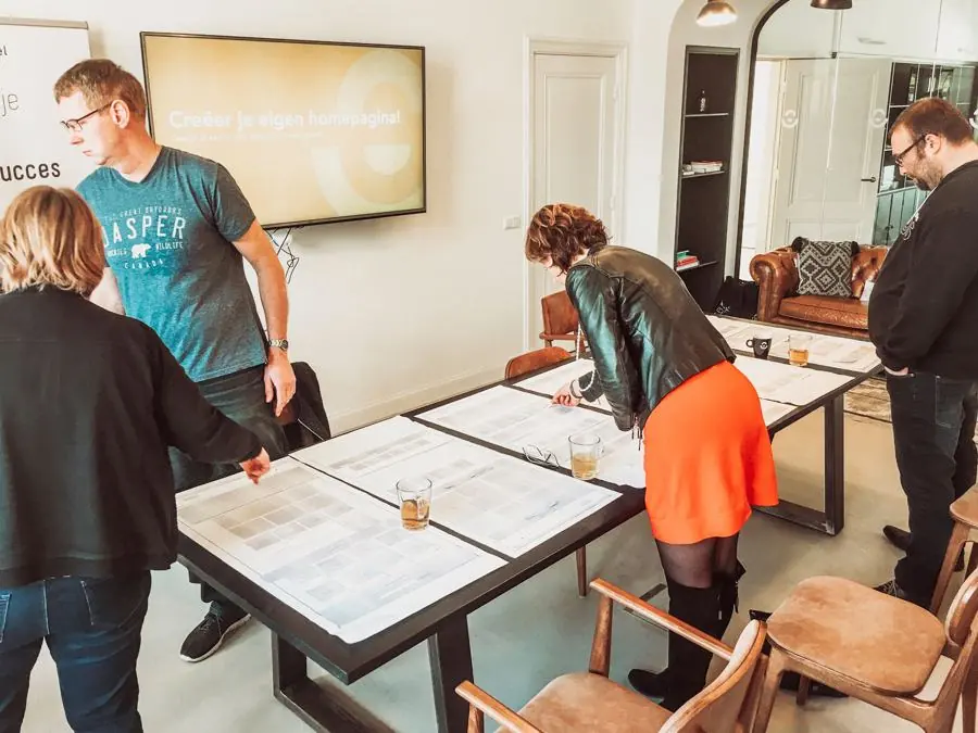 Deelnemers leggen papieren blokken op tafel